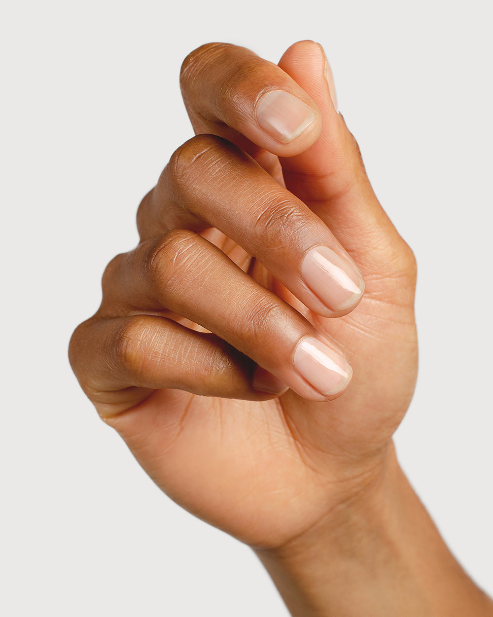 transparent base and top coat hand swatch on medium skin tone by sienna