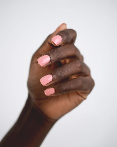 peachy pink nail polish hand swatch on dark skin tone